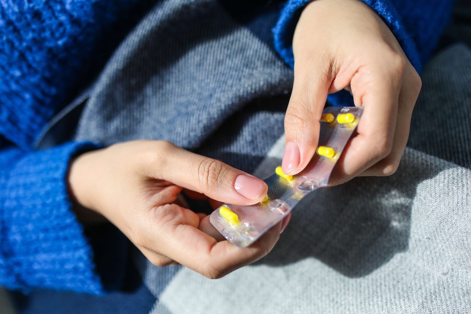 Hands holding a medication blister pack