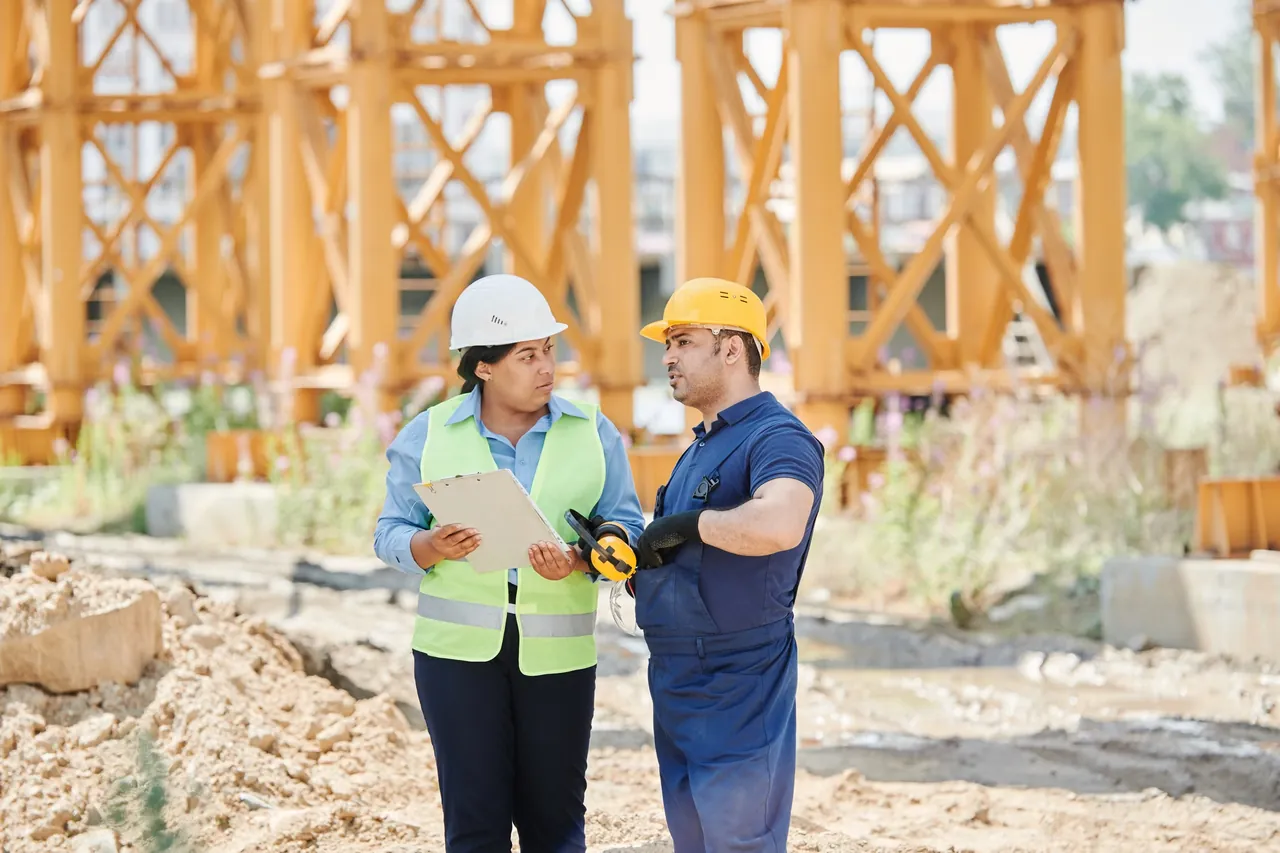 Two independent professionals reviewing plans at a job site